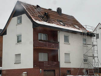 Foto von zwei Dachdeckern, die im Winter auf einem Dach ohne Sicherung arbeiten. – Bildquelle: Bernd Heupel