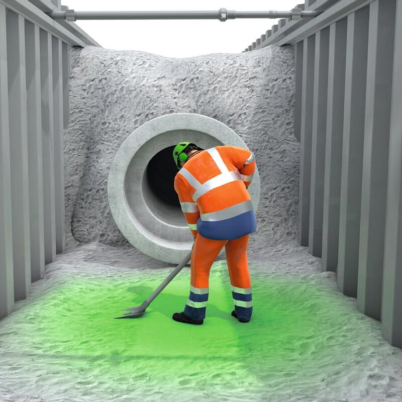 Ein Bauarbeiter arbeitet in einer korrekt verbauten Baugrube.