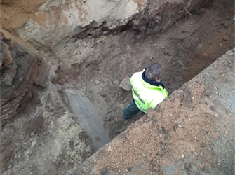 Fotos eines Bauarbeiters, der in einem tiefen Graben ohne Helm geht. – Bildquelle: Arne Lehmeier